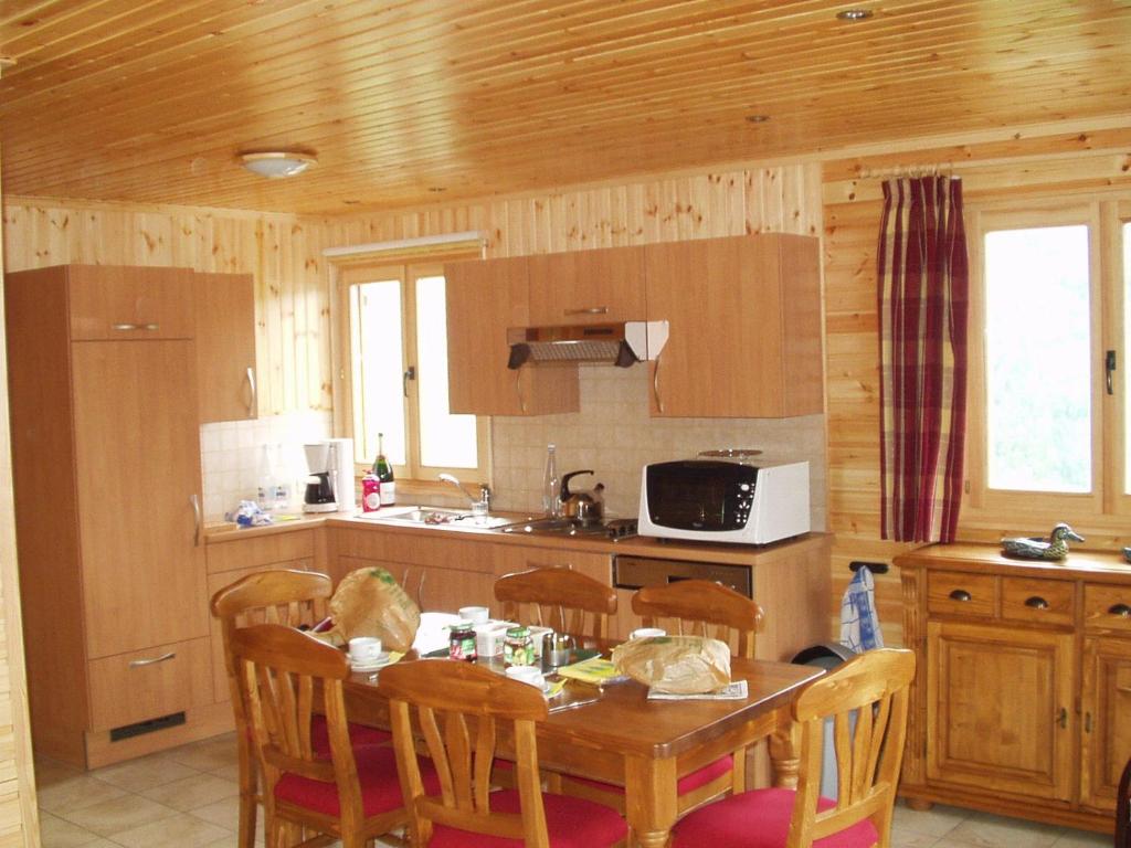 a kitchen with a wooden table and chairs and a table and a tableablish at Les Rochettes Pluton 3 in La-Roche-en-Ardenne