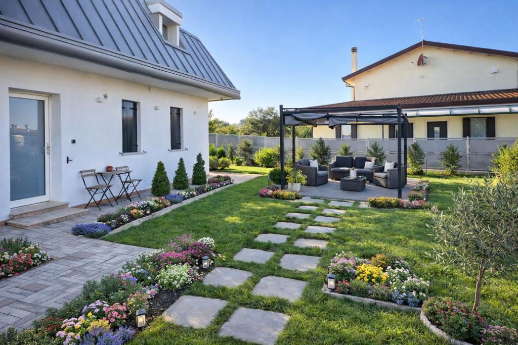een tuin met een patio en een huis bij QUEEN HOME Emanuelle in Venetië