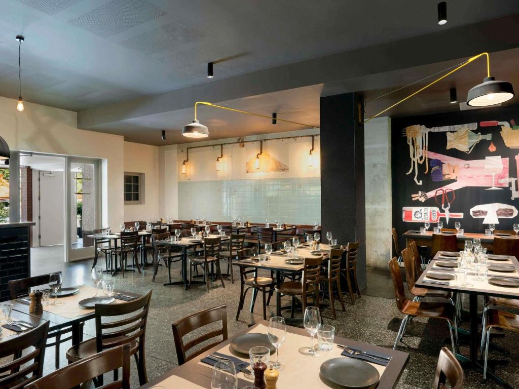 een eetkamer met tafels en stoelen in een restaurant bij Peppers Gallery Hotel in Canberra