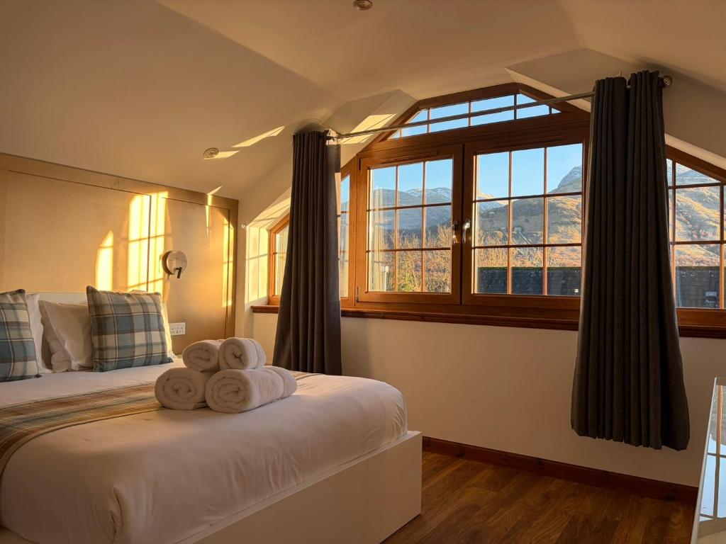 a bedroom with two towels on a bed with a window at Sheraton Apartments in Fort William