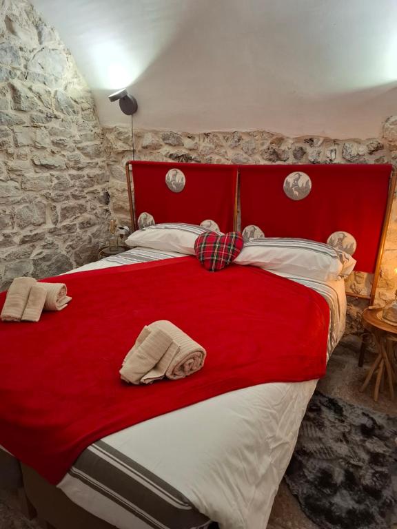 ein Schlafzimmer mit einem roten Bett mit Handtüchern darauf in der Unterkunft LA CASA DI ROSA in Rivisondoli