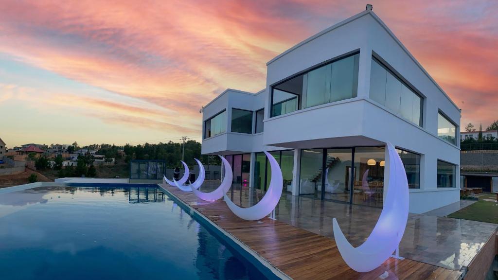 a house with a swimming pool in front of a sunset at Ricefield Valley in Mandriankeniheny