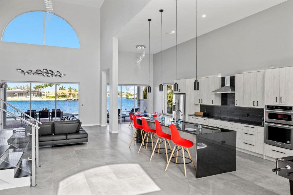 een keuken met een bar met rode stoelen erin bij Villa Stella in Burnt Store Marina