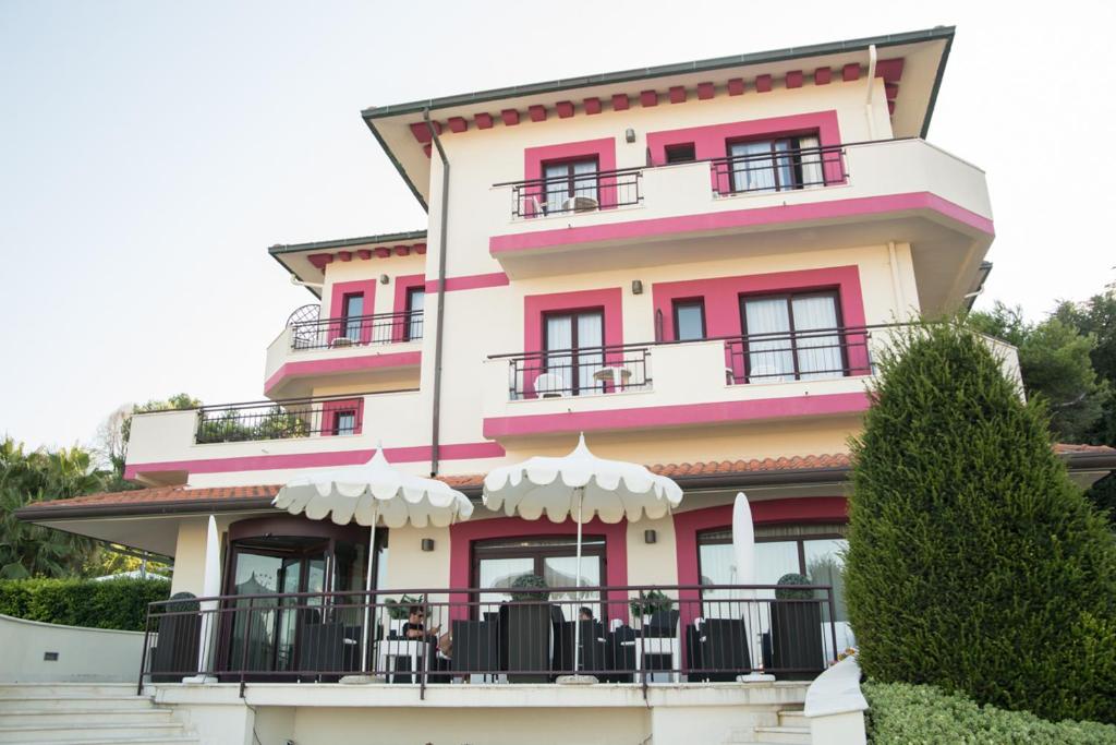 a pink and white building with a balcony at Hotel Levante in Fossacesia