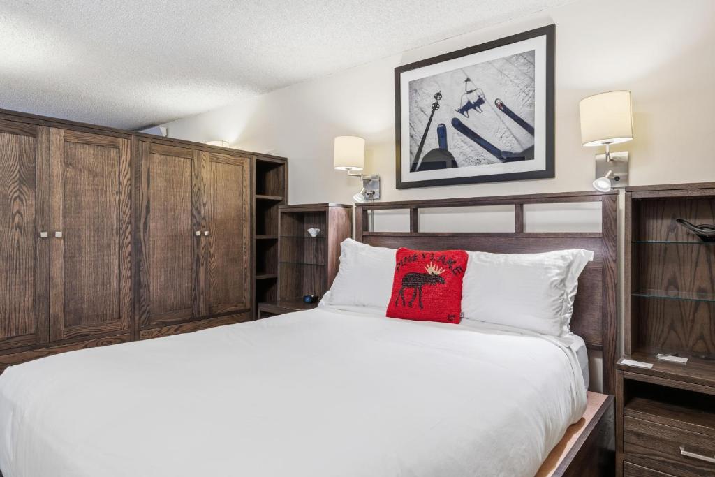 a bedroom with a bed with a red pillow on it at Lift House Lodge, Pet Friendly, Premium Studio Condo in Vail