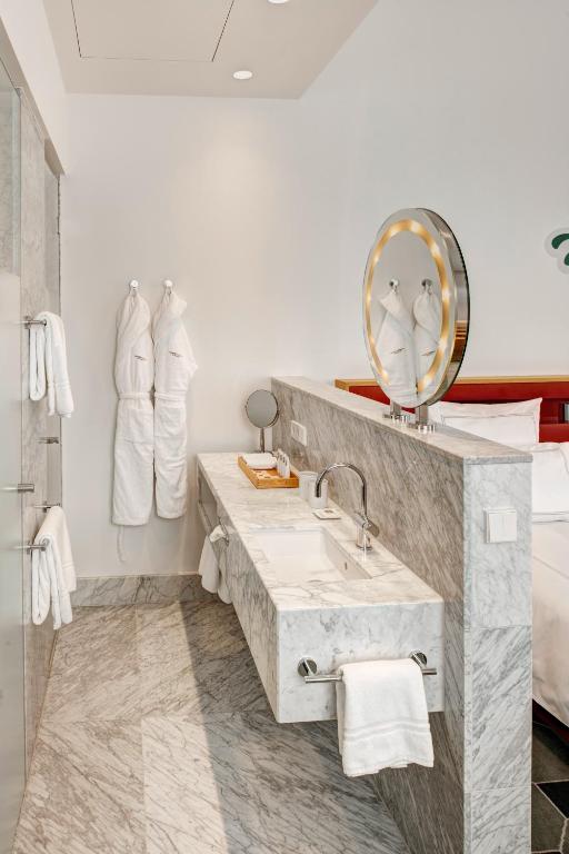 a white bathroom with a sink and a mirror at HYPERION Hotel Dresden Am Schloss in Dresden