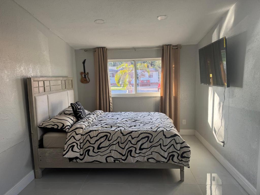 een slaapkamer met een bed met een zwart-wit dekbed bij Private Studio with Patio-King Bed, Near Beach & Casinos in Hollywood