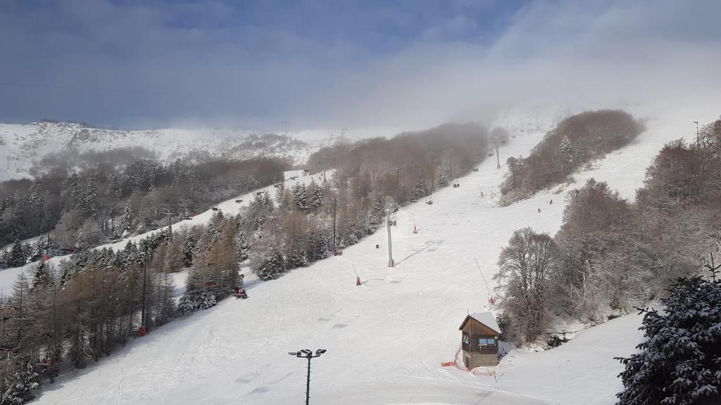 a snow covered ski slope with a ski lift at Studio-cabine au pied des pistes à Super Besse in Super Besse