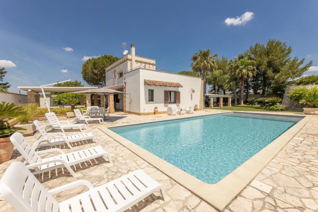 una villa con piscina e sedie di Villa Mare Salento a Taurisano