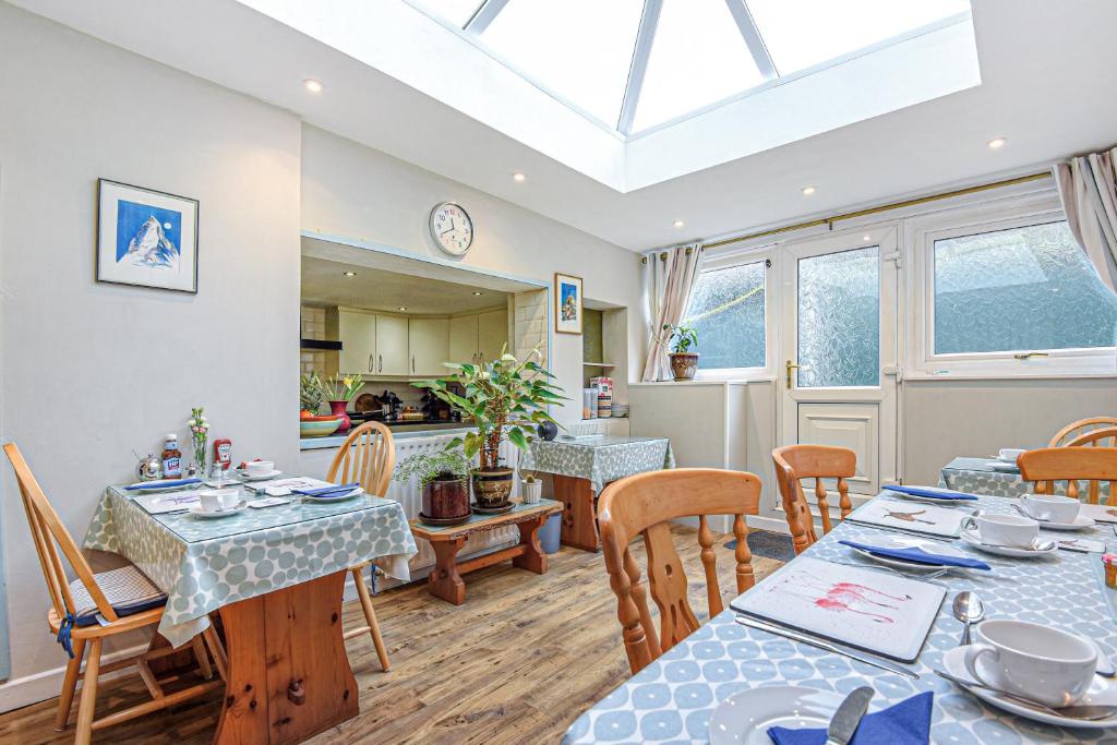 a dining room with tables and chairs and a skylight at Capritia Guest House in Dartmouth