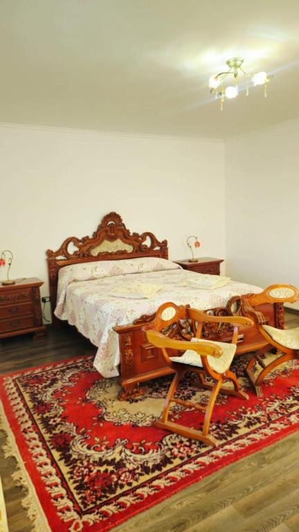 ein Schlafzimmer mit einem großen Holzbett und einem Teppich in der Unterkunft Casa Sulfina in Radoşi