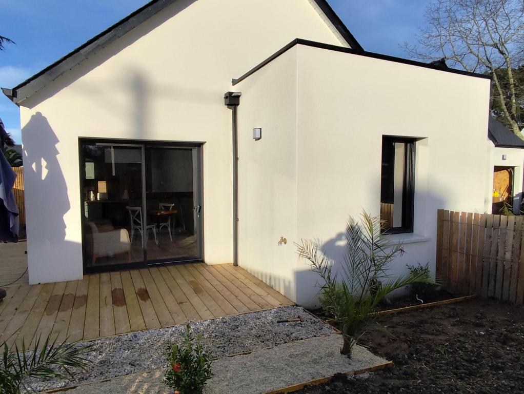 una casa bianca con una grande porta scorrevole in vetro di Kercabellec a Mesquer