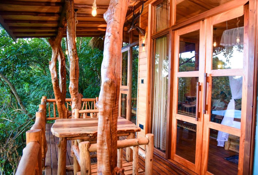 a wooden porch with a wooden bench on a house at Eco Cabins Hideaway Ella in Ella