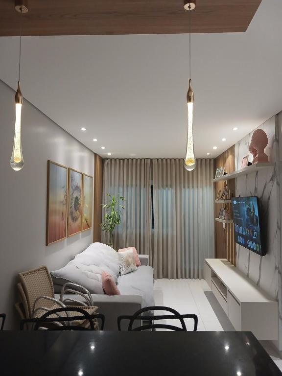 a living room with a bed and some chairs at Calmaria in Matinhos