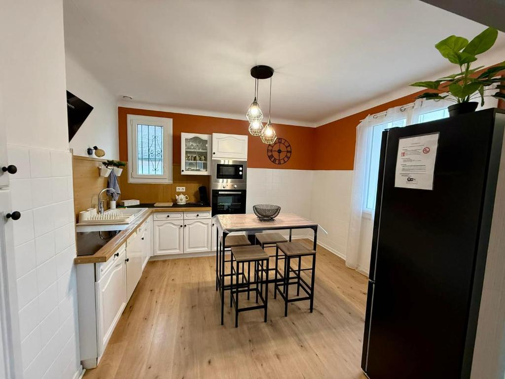 a kitchen with a black refrigerator and a table at Un Mendi in Argelès-Gazost