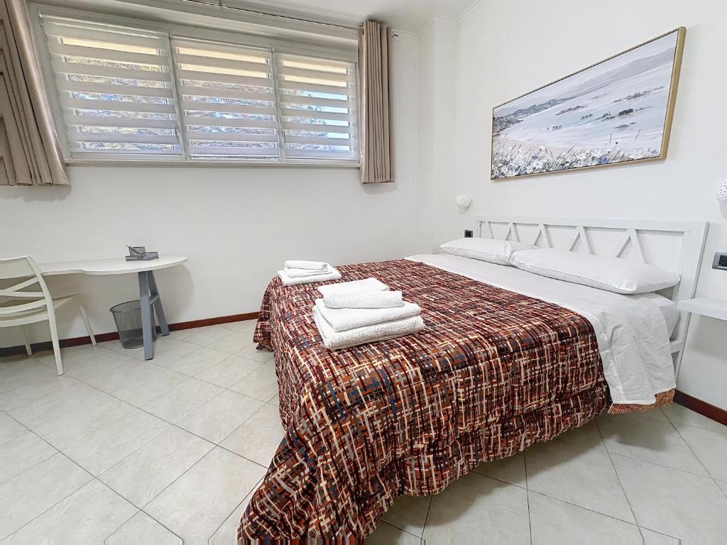 een slaapkamer met een bed, een tafel en een raam bij Alloggio Turistico - I tre Moschettieri - Zona Universitaria e Tribunale Nuovo in Viterbo