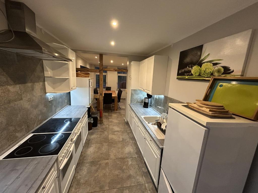 eine Küche mit weißen Geräten und einer Arbeitsplatte in der Unterkunft Helmstedt Zentrum - Gemeinschaftshaus & Garten in Helmstedt