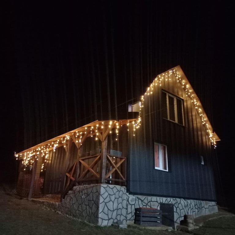a barn with lights on it at night at Горянка in Oryava