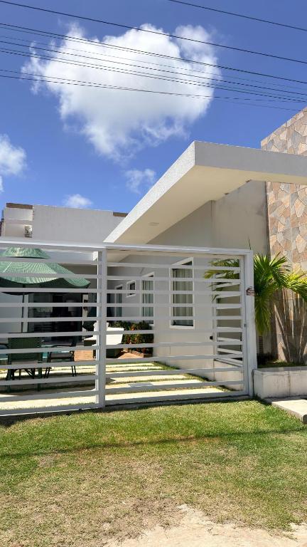 a white house with a bench in front of it at Casa com Piscina em Tamandaré in Tamandaré