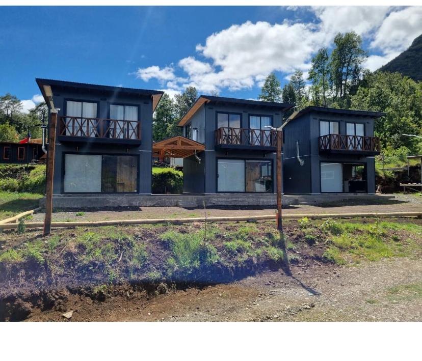 una grande casa blu con due balconi di Cabañas alto de coñaripe a Coñaripe