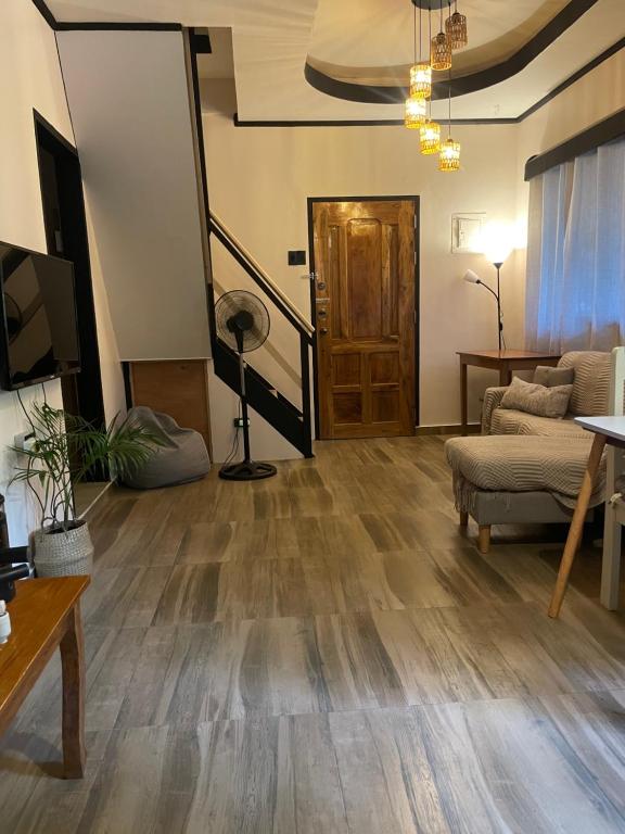 Il comprend un salon doté de parquet et d'un escalier. dans l'établissement Shaka Soul Siargao, à Catagnan