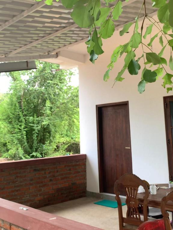 a room with a table and a wooden door at Wilpattu Nuga Lodge in Pahala Maragahawewa