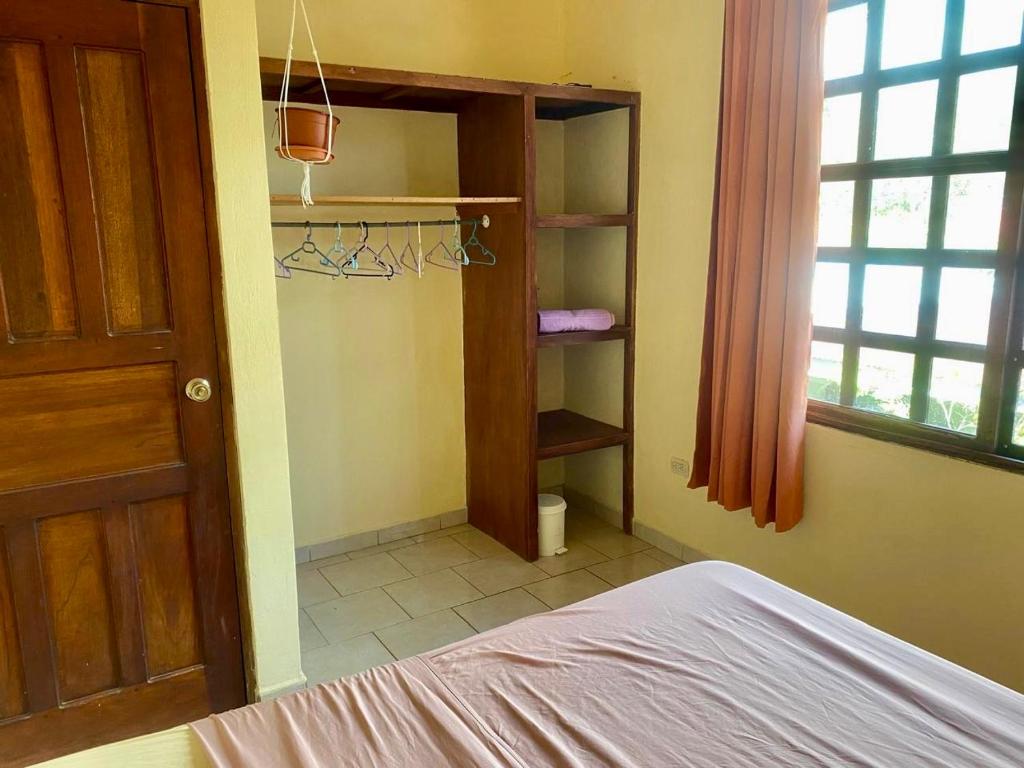 een kamer met een slaapkamer met een bed en een raam bij Casa Ocho in Jacó