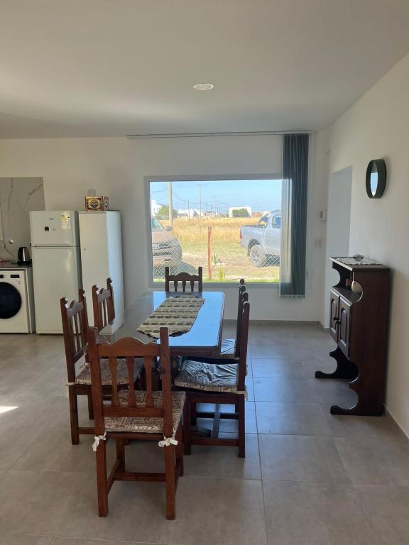 a dining room with a table and chairs and a kitchen at Ecos de mar in Mar del Sur