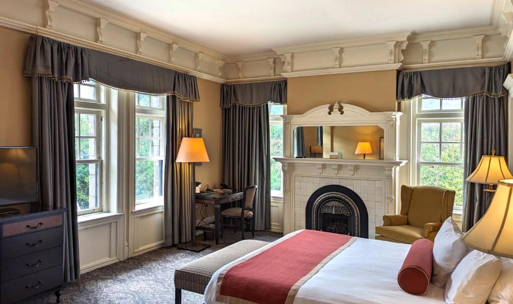 een slaapkamer met een groot bed en een open haard bij Mansions on Fifth in Pittsburgh