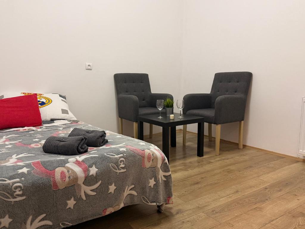 a bedroom with two chairs and a bed and a table at Silesia młyn in Katowice