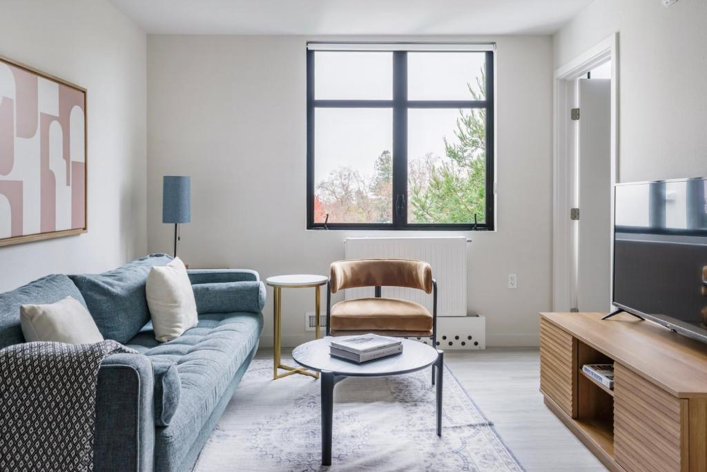 een woonkamer met een bank, een tafel en een tv bij Blueground Central Berkeley rooftop nr UC Berkeley SFO-2124 in Berkeley