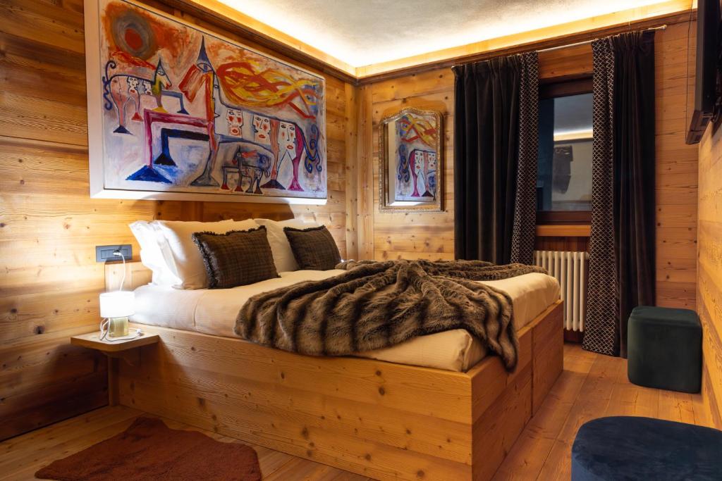 een slaapkamer met een bed in een houten kamer bij Maisons Grandes Murailles in Valtournenche