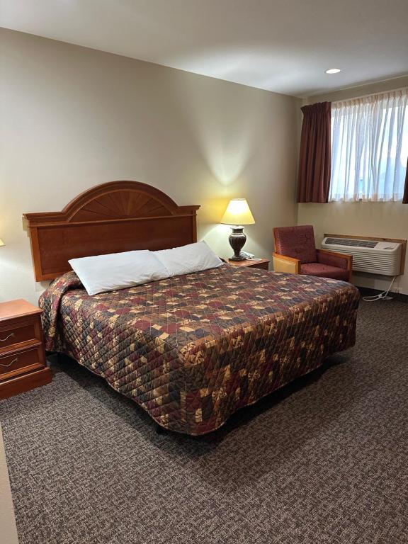 a hotel room with a bed and a chair at The Rushford Inn in Rushford