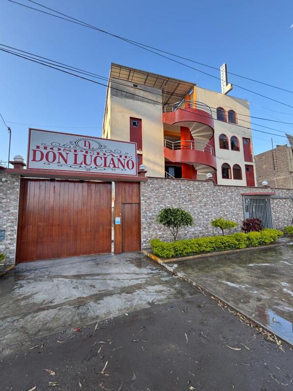 un bâtiment avec un garage muni d'un panneau. dans l'établissement Hospedaje Don Luciano, à San Vicente de Cañete