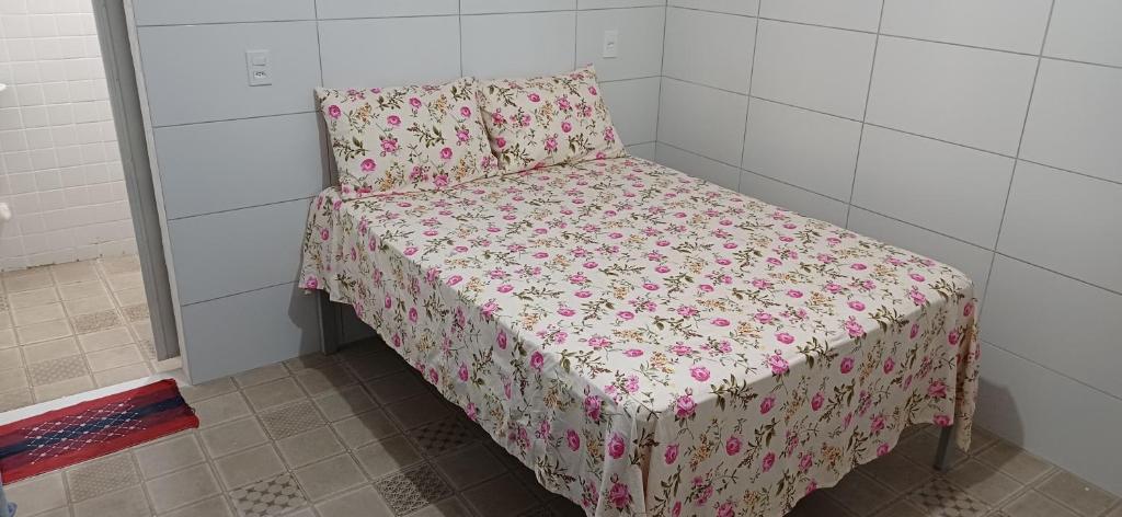 una piccola camera da letto con un letto con una coperta rosa di Taberna dos Castilho 1 a Bertioga