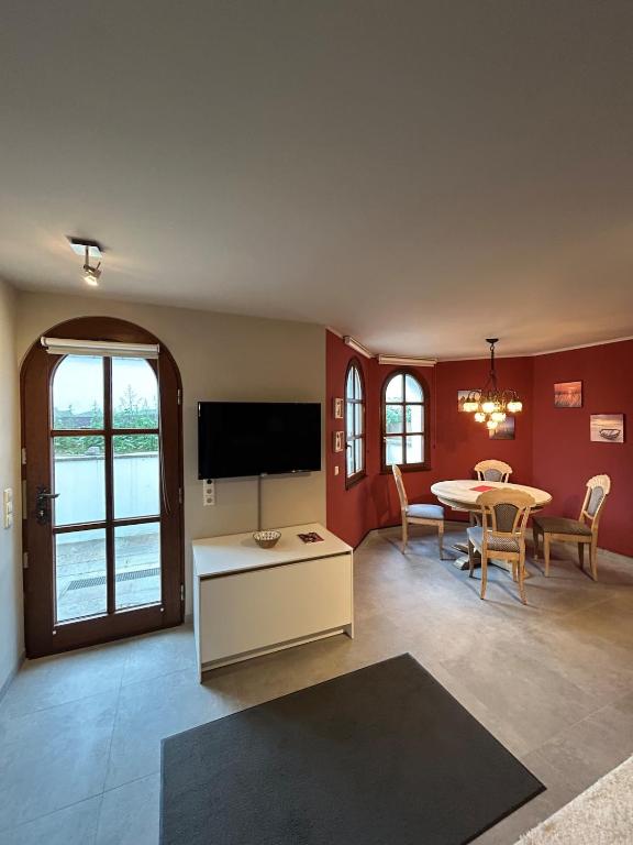 a living room with a table and a tv at Helle Souterrain-Wohnung mit eigenem Eingang in Erftstadt