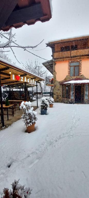 a yard covered in snow in front of a building at Guesthouse Zaqara in Borjomi