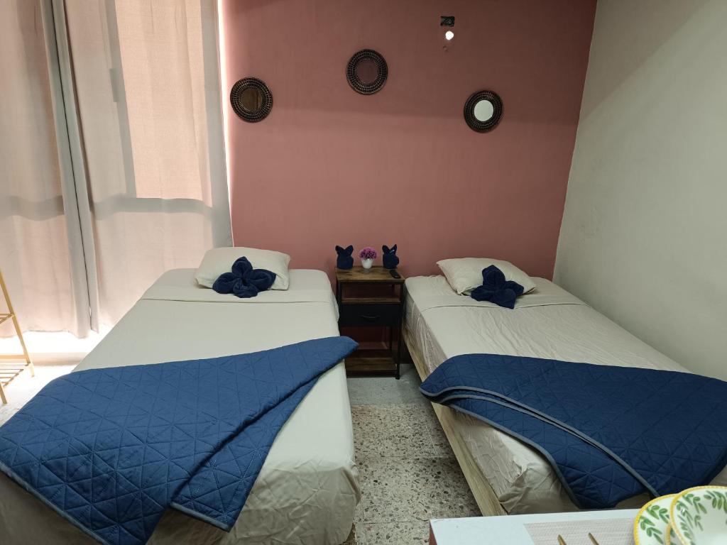 twee bedden in een kamer met blauwe kussens erop bij Habitación 102 Cordoba Centro Estacionamiento in Córdoba