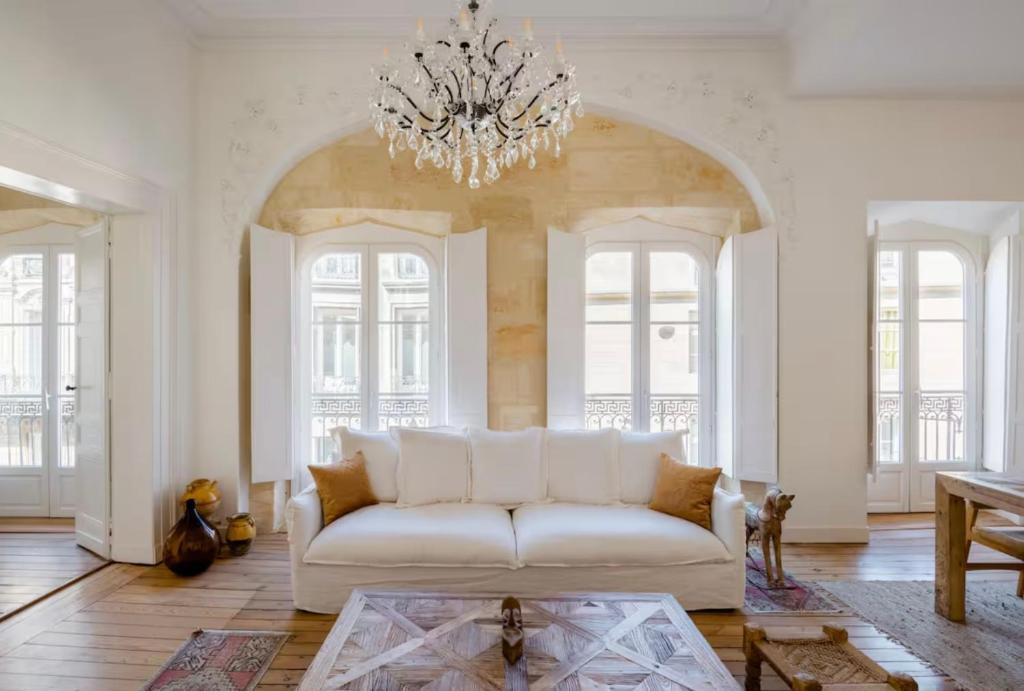 een woonkamer met een witte bank en een kroonluchter bij Splendide Appartement a coté de la Mer Calme 2 Room Wifi Tramway in Nice