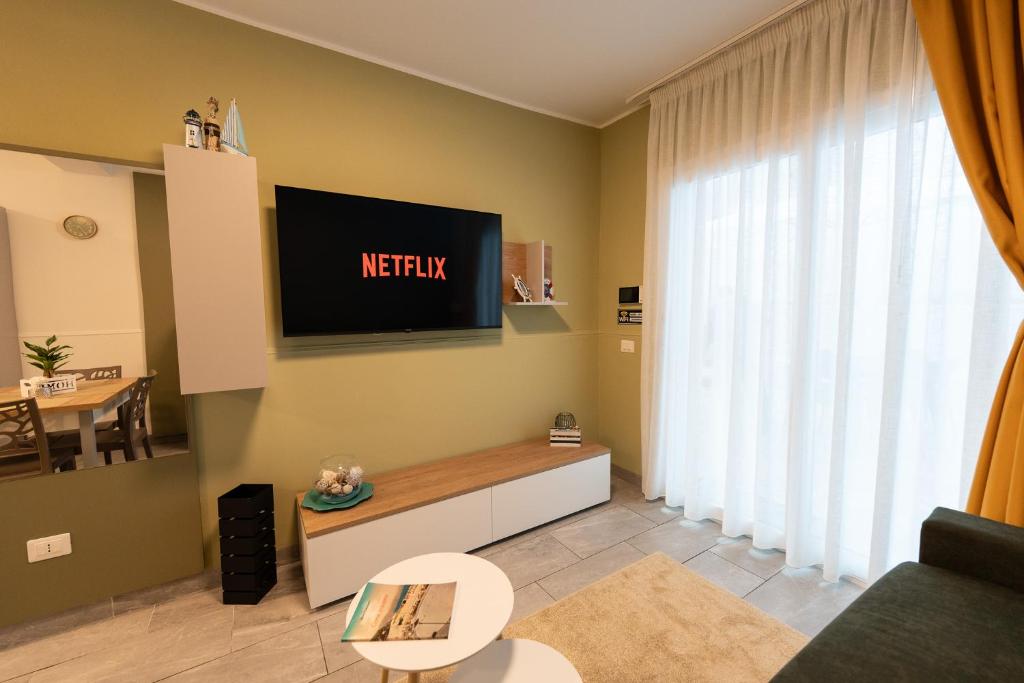 a living room with a television on the wall at B&B Maison Sophie SOVERATO MARINA in Soverato Marina