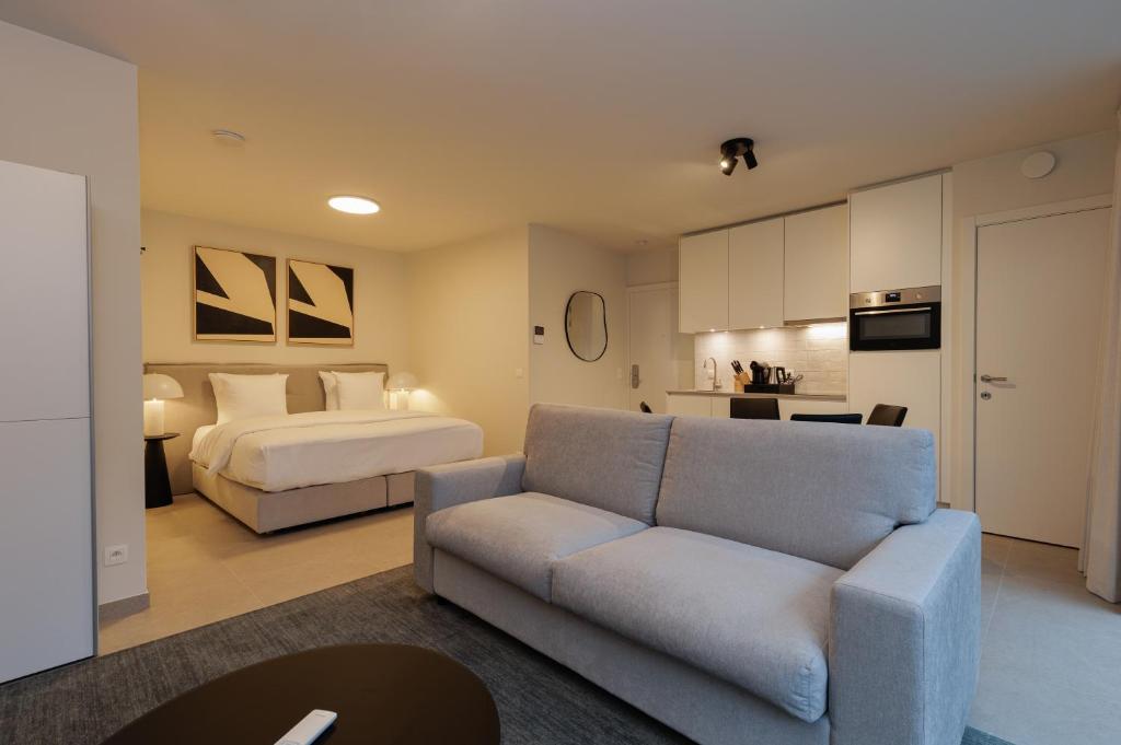 a living room with a bed and a couch in a room at X-Corner Ostend - Casselbergh Residences in Ostend