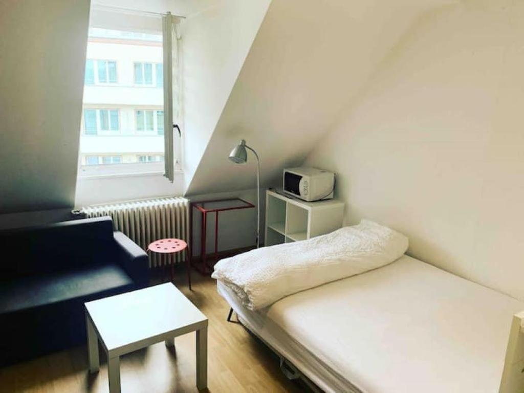 un piccolo soggiorno con letto e tavolo di Zurich HB Station Studio, Leon a Zurigo