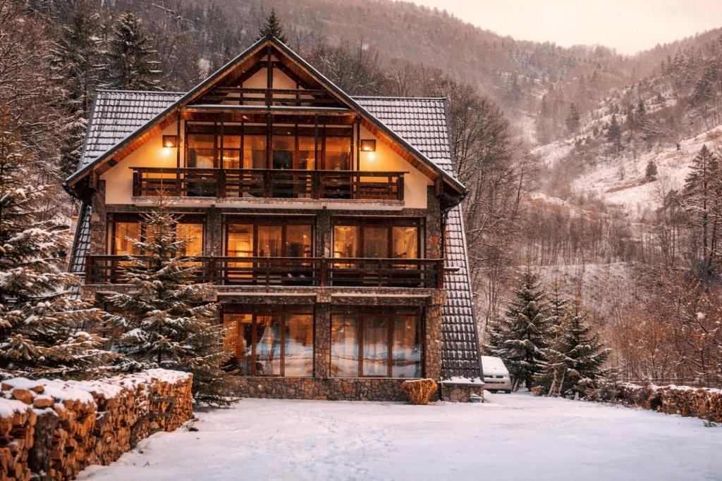 a log cabin in the mountains in the snow at Cabana Riverdale in Podu Dîmboviţei