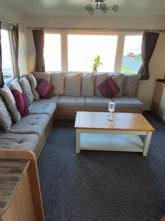 een woonkamer met een bank en een salontafel bij Lyon's Robin Hood Rhyl 8 Berth Caravan in Rhyl