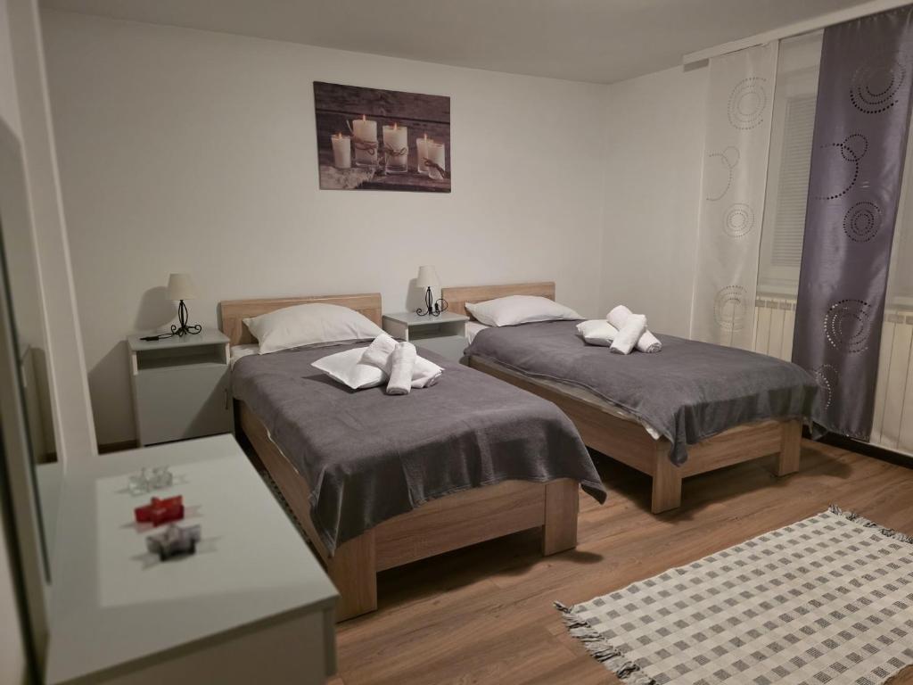 a bedroom with two beds with towels on them at Apartman Antea in Otočac
