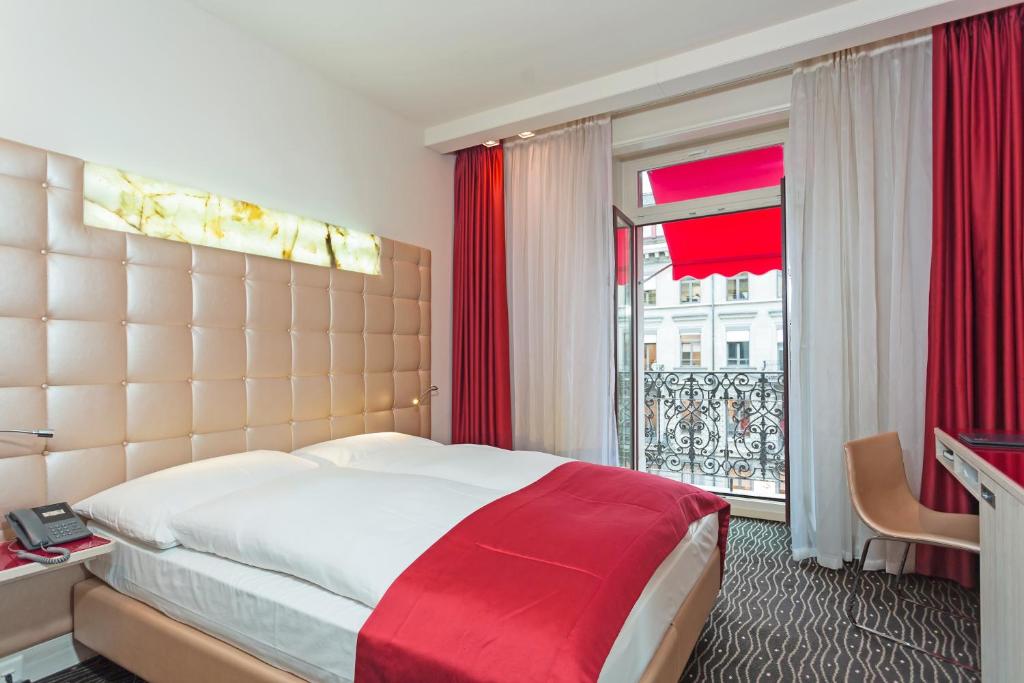 a hotel room with a large bed and a window at Hotel St.Gotthard in Zürich