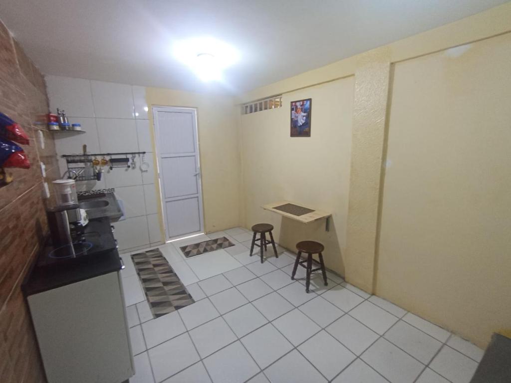 a small kitchen with a table and two stools at kit Net B in São Luís