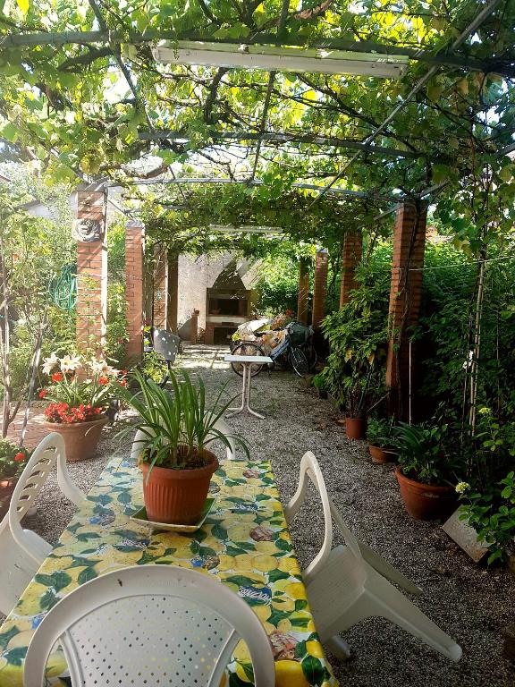 a patio with a table and chairs and plants at Appartamento Cervia in Cervia