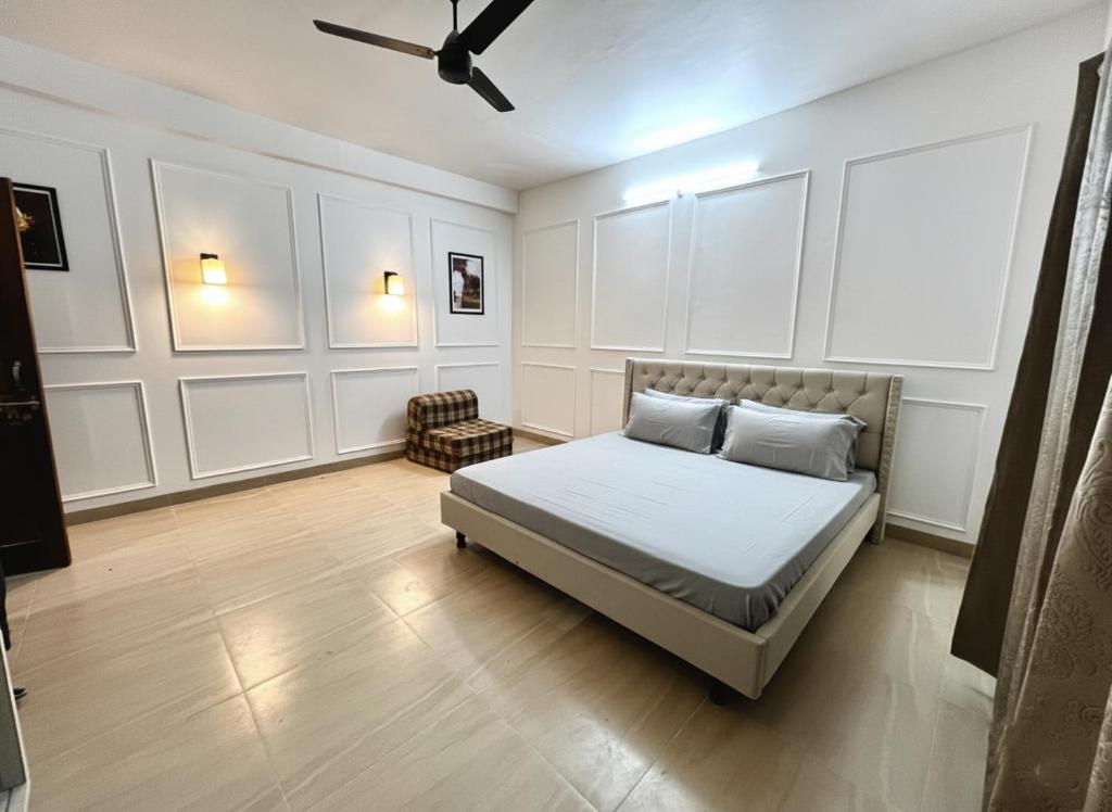 een slaapkamer met een bed en een plafondventilator bij Himalayan Hideaway in Almora