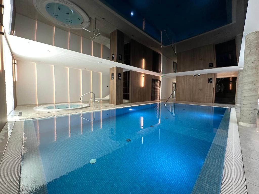 een zwembad in een gebouw met een klok aan de muur bij Dune & Sea in Ustronie Morskie